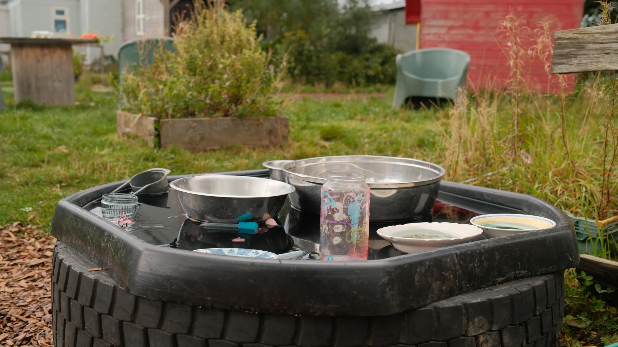 Metal bowls and pans on an outdoor tyre table
